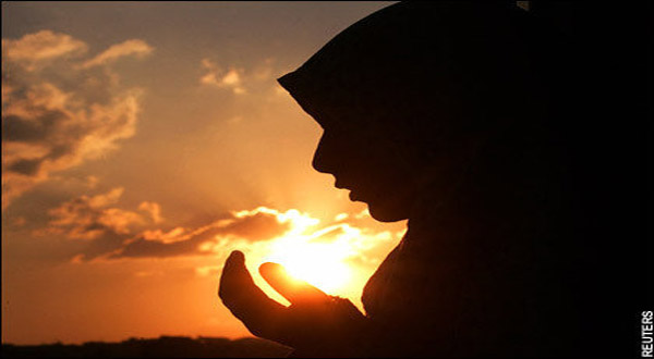 A Muslim woman raising her hands in supplication.